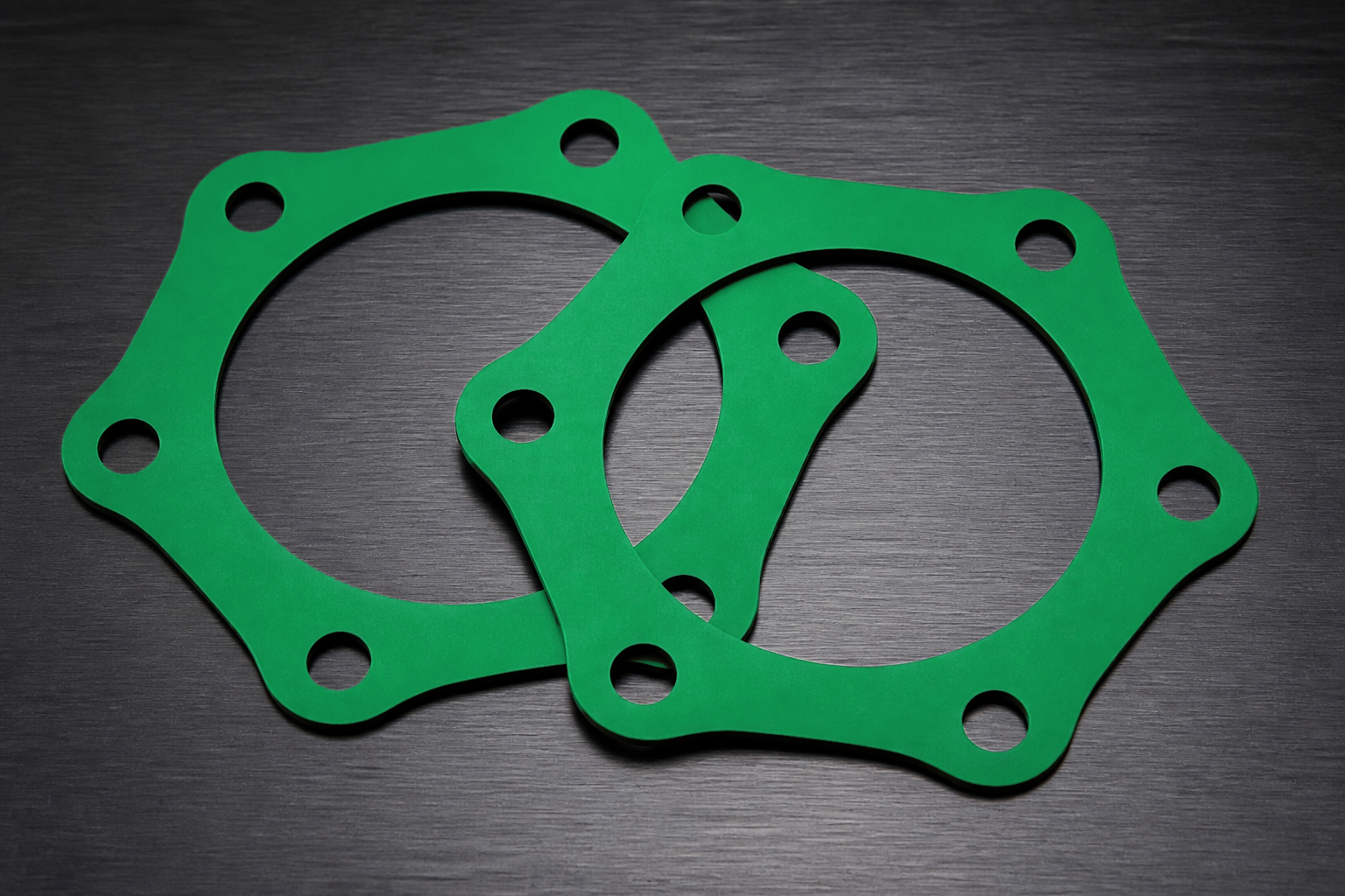 Two green coated industrial gaskets